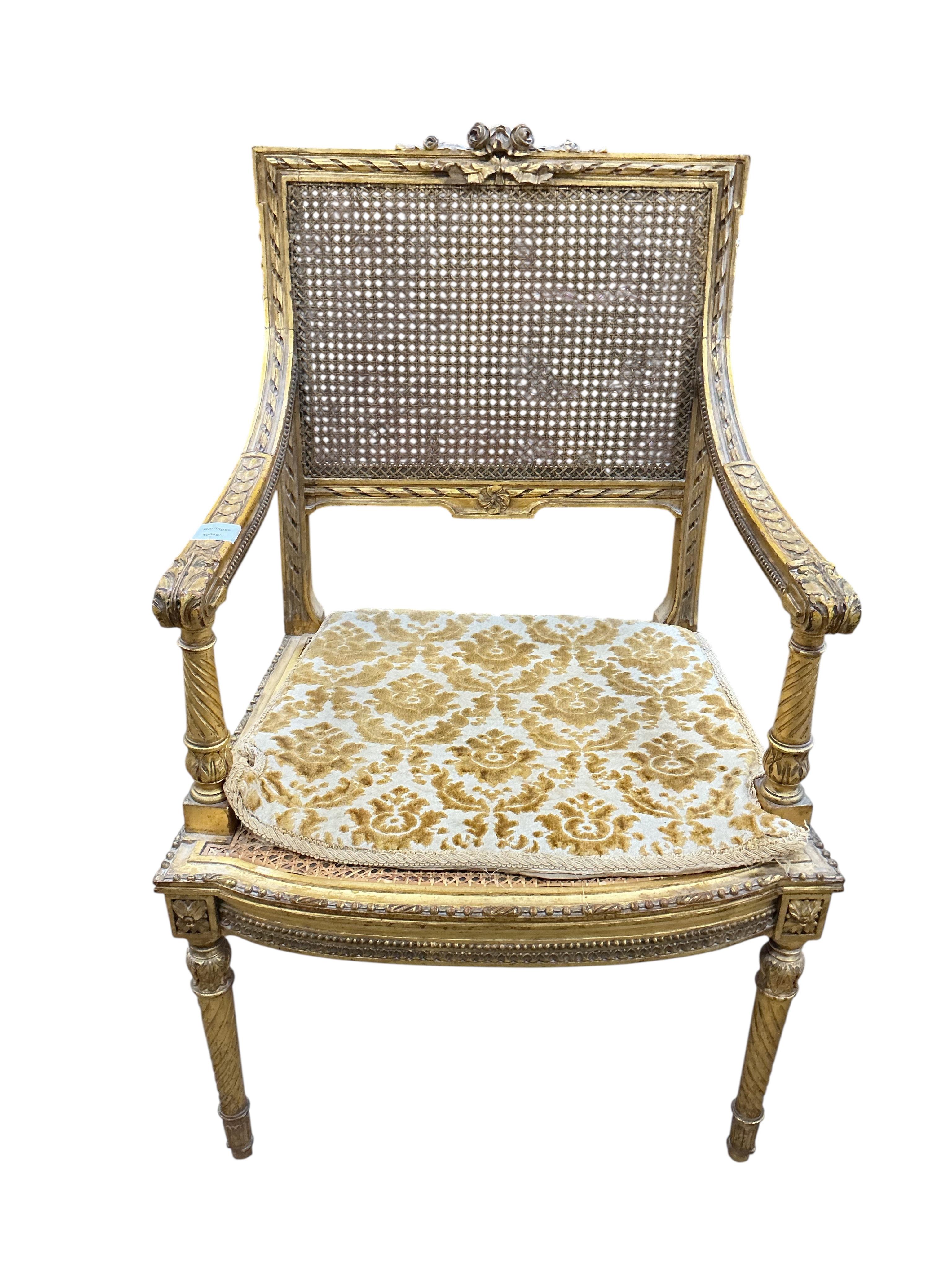 A late 19th century French Louis XVI style open elbow chair with cane seat, a matching side chair and another giltwood side chair